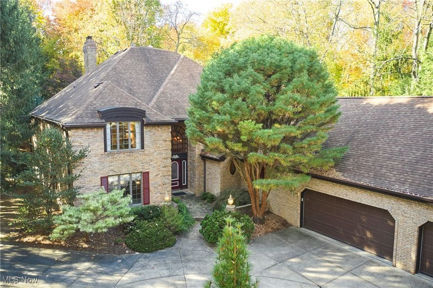 Private Retreat with First Floor Primary in Bath Township.  Enjoy privacy, nature, and timeless craftsmanship in this elegant Schleider-built Tudor nestled within The Sanctuary—one of Bath Township’s most desirable neighborhoods.  The home’s unique and stylish layout features a first-floor Primary Suite with two walk-in closets and an oversized bath. The two-story sunken Great Room impresses with a fireplace, wet bar, and stunning views of the wooded lot beyond. A sunroom tucked at the back of the home offers the perfect nature haven for morning coffee or quiet reflection.  The main level also includes a welcoming foyer with curved staircase, formal Living and Dining Rooms, a cozy paneled Den, and a versatile Office or Sitting Room, generous laundry with window and storage, and two (2!) half baths.. The spacious eat-in Kitchen boasts a center island, walk-in pantry, generous dining area, and access to a grilling deck. Upstairs, discover three additional bedrooms, including one large enough to serve as a second Primary Suite. All bedrooms feature walk-in closets, with an additional walk-in storage closet on the landing. The finished lower level offers a Rec Room, guest room, and half bath, plus two expansive unfinished areas perfect for storage, workshop, fitness space—the possibilities are endless. A three-car garage with extra storage pad and an alcove provides ample space for vehicles and outdoor equipment. Newer AC. The wooded lot, bordered in part by a meandering creek, adds a serene, natural backdrop.  Residents of The Sanctuary enjoy public water and sewer, varied architecture, proximity to shopping, dining, highways, parks, and more, and of course, the top-rated Revere School District.  Call today for your private showing and see how you can make this wonderful property your own!