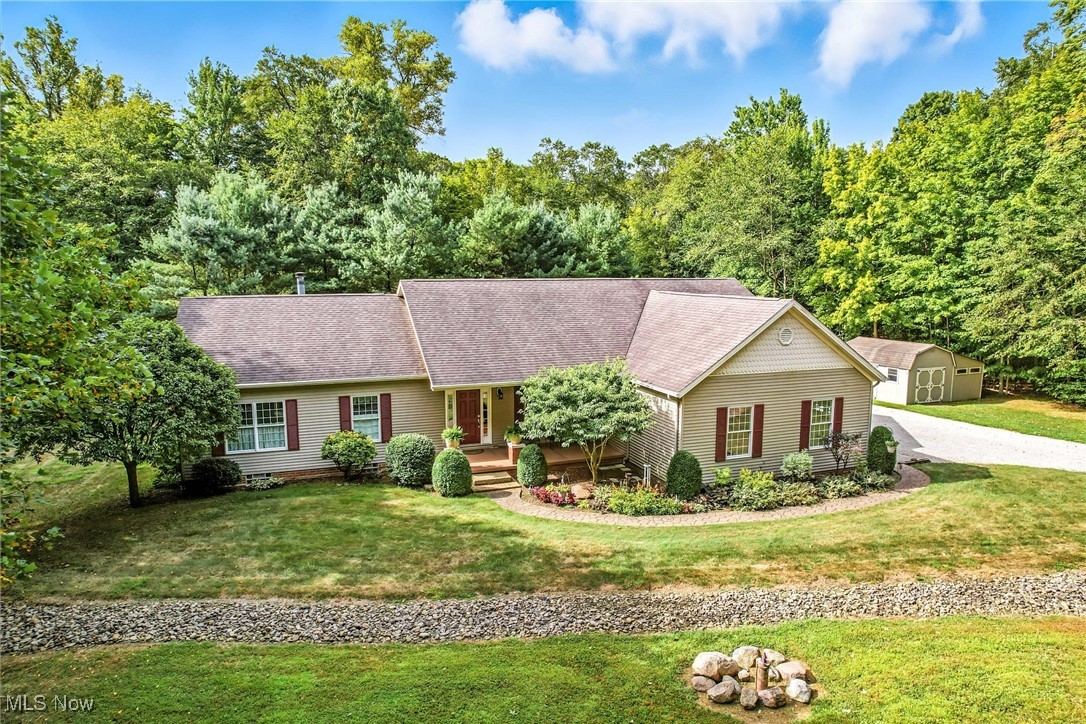 Amazing secluded ranch home built in 2003 with a 3 car attached garage, and one more garage situated on 10.4 acres! These are the original owners who custom built this house. The home features 9 foot ceilings with crown molding and recessed lighting throughout, with the added benefit of insulated interior walls. Most of the flooring, baseboards and much of the trim work are made from hardwood maple sourced from the property. The kitchen includes a breakfast bar with granite countertops, maple cabinets, under-cabinet lighting and a pantry. There's also an eating area by the kitchen as well as a formal dining room. On one side of the home you will find the master bedroom with a master bathroom featuring two separate sinks, a full shower, garden bathtub and walk-in closet. Adjacent to the master bedroom is an office which could also serve as a nursery, work out room, fourth bedroom etc. On the other side of the home there are two additional bedrooms, a full bathroom and a laundry room. The great room boasts a fireplace and a wall of windows, offering wooded views and abundant natural light. A three-season room is located off the kitchen with windows and screens. The basement is larger than the 2,248 sq ft of the main home, extending under the three-season room. It is a walkout basement with 4 double-hung windows providing natural light, currently used as an art studio. While unfinished it offers endless possibilities! There's also a wood burner in the basement tied into the heating system. Updates include new heat pump in 2019, new flooring in the 3 seasons room in 2022, new water softener in 2024. Outside the property is beautiful with stone trails extending over 1/4 mile into the woods, with a bridged culvert that provides tractor access to the entire wooded lot. Property includes two out buildings, one is 12x20 with windows and overhead garage door. The other outbuilding is a 12x14 utility shed with a lean-to for additional equipment.