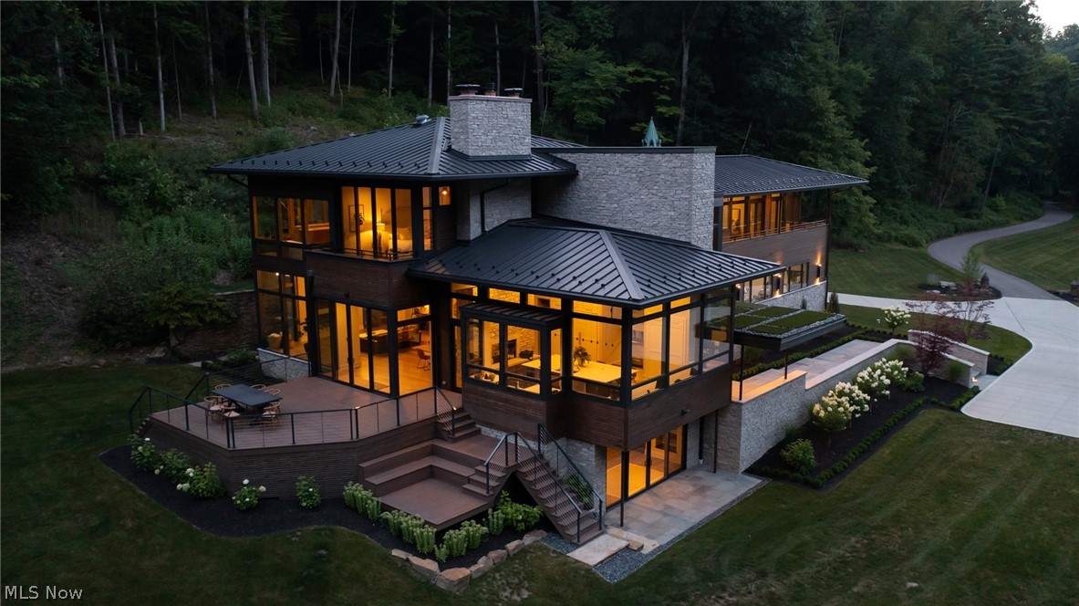 Contemporary architecture and the philosophy of form-following-function are hallmarks of this house, a study in glass, wood, and stone. Situated on 19+ acres in the Yellow Creek Valley, this home was designed to frame views of the surrounding hillside and waterfall, with historic remnants from the previous estate including a mill wheel, stone horse bridge, dovecote, and bath house. The river runs the entire length of the property, accompanied by shale cliffs and natural pools that function as your own private park. From the moment you step through the black walnut front door, everything about the home emphasizes spaciousness, openness, and natural light, all enhanced by a minimalist perspective. French oak floors and stained cedar ceilings bring warmth to the open space. Designed for entertaining, an expansive chef's kitchen, massive great room, multi level deck, and various fireplaces are the hallmarks of the first floor. Throughout the home, floor to ceiling windows frame the natur