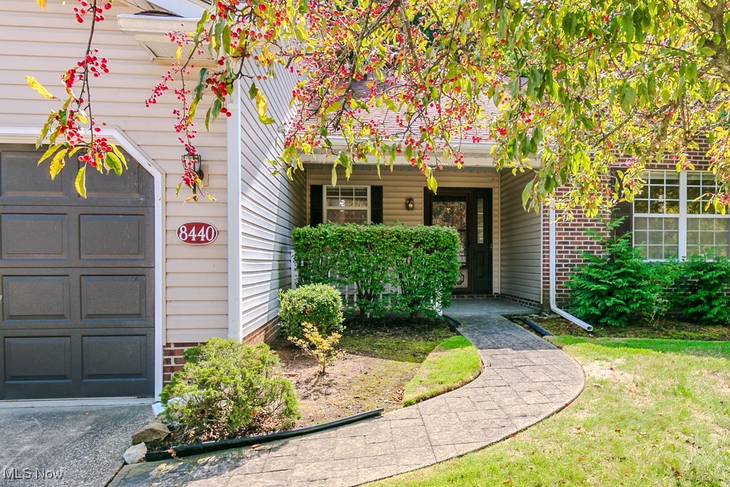 8440 Bartley Ln. — Rare, true ranch condominium in highly desirable Governors Place Condominiums, offering a bright, open plan and effortless single-level living. A charming covered front porch with stamped-concrete walkway welcomes you into a generous foyer with coat closet, where the home opens to a sun-splashed ensemble of rooms framed by picture windows. The kitchen, living, and dining rooms are united beneath expansive vaulted ceilings, creating an airy sense of volume ideal for daily living and entertaining. The eat-in kitchen features a large dinette area sized for a full breakfast table, two skylights that wash the space in natural light, and all appliances included. A rear family-room bump-out—lined with windows—adds flexible gathering space and connects through sliding glass doors to a covered deck overlooking a wooded backdrop for private outdoor relaxation. The bedroom wing includes two bedrooms and two full baths, with Bedroom 2 offering excellent wall space and its own vaulted ceiling; a nearby laundry room doubles as a mud room for everyday convenience. Storage is abundant throughout, including an attached two-car garage with additional capacity. Set moments from Lake Erie, local yacht clubs, the Mentor Civic Center, major shopping corridors, and with easy access to Rt. 2, the location balances tranquility with unmatched convenience. Life in Governors Place means low-maintenance living along tree-lined streets overseen by professional property management; recent association updates include gutter guards, refreshed garage trim, and other thoughtful improvements that underscore the community’s ongoing care. A special opportunity to enjoy true one-floor living in a beautiful, well-kept environment—move-in ready and perfectly situated in the heart of Mentor.