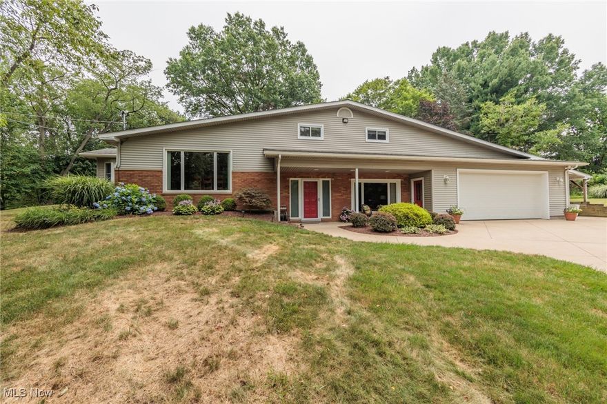 Wow!!  Do not miss this opportunity to own this unique, certainly one of a kind, Tallmadge split level on over an acre.  This 4 bedroom, 2.5 bath split level has over 2500 square feet.  A huge family room is at the main level at the ground, and features an awesome wood burning fireplace, half bath, and access to the deck.  The main level features an updated kitchen, large dining room, a large formal living room with vaulted ceilings... and an amazing 26x19' master suite with a  12x8 walk-in closet and 12x12 bathroom.  The master bath has a double stand up shower, double sinks, a garden tub, and ceramic floors.  The upper level has 3 good sized bedrooms and a nice bathroom.  The lowest level is huge, with a workshop, high ceilings, carpeted, cabinets, a 200 amp electric panel, and more.  The attached garage is a monster at 31x27, and also has a big carport off of the side.  The wooded acre features a giant natural wood deck, shed, and wonderful landscape.  There is believed to be natural wood floors under most of the upper carpet.