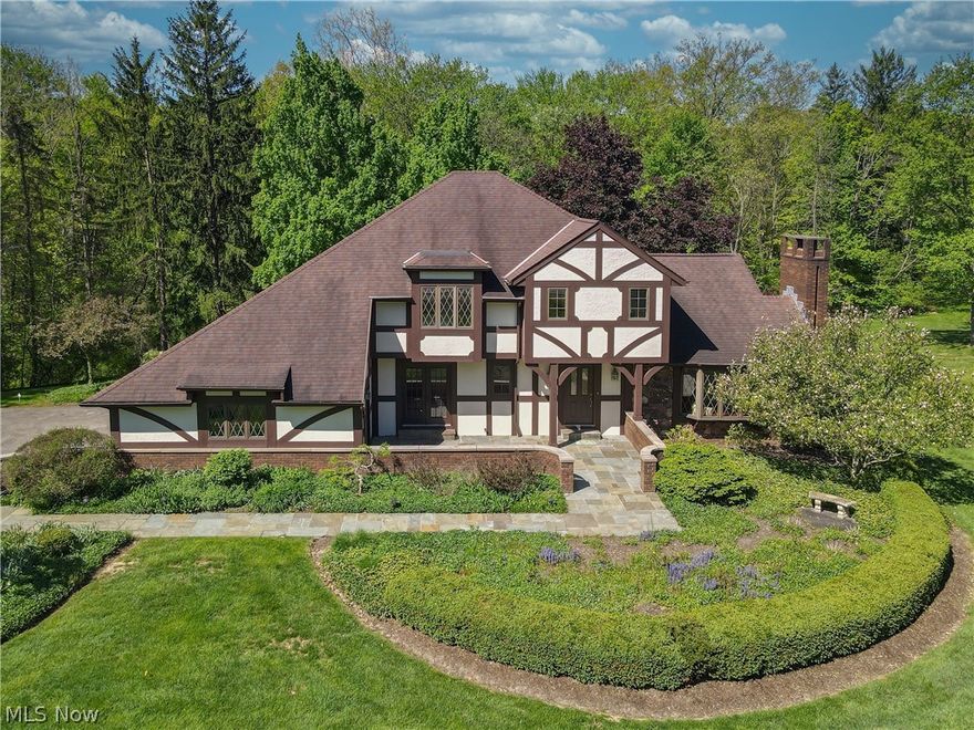 Welcome to heaven on earth and a short walk to the Village of Chagrin Falls. When you arrive home, you are greeted with a cathedral of trees as a backdrop and the sights and sounds of Mother Nature surrounding this beautiful English Tudor. The stone front courtyard takes you to the foyer and the formal living room with wood floor and wood burning fireplace. To the left the formal dining room(new chandelier) is spacious enough for large celebrations or romantic dinner for two. Next is the beautiful, totally remodeled powder room and laundry room with a door to the backyard. Great for in and out, outdoor play, for pets and little ones. The updated kitchen(newer fridge, microwave, wall oven and NEW hardware and lighting) has cabinets galore and flows into the family room with engineered hardwood flooring and lighting. Slider in the family room exits to the deck and OH,WHAT A VIEW! Up to the 3 bedrooms with the owner's suite featuring a new walk-in closet. One of the bedrooms has a "secret