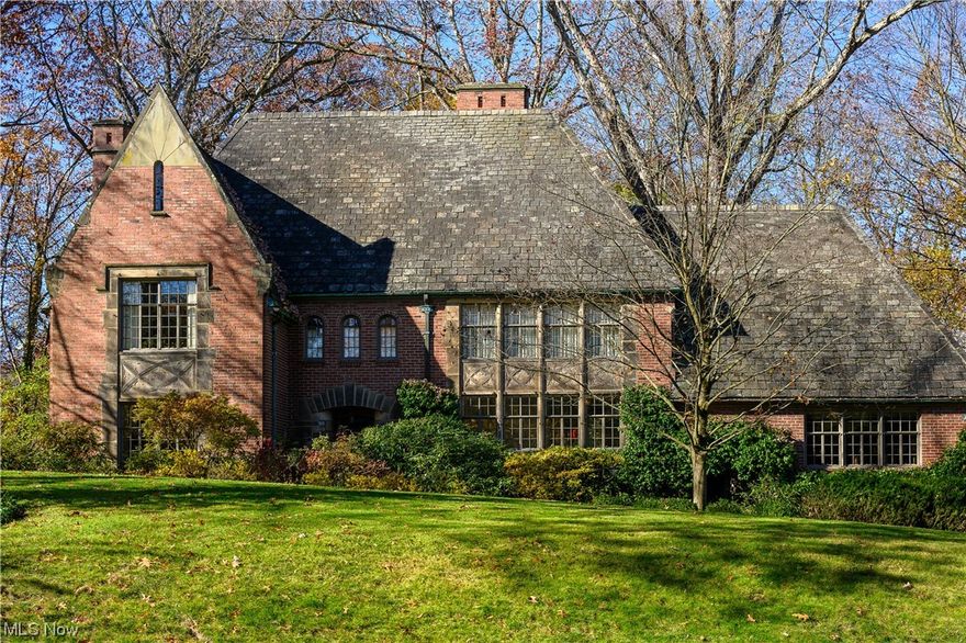 Become the third owner of this historic home in park-like Hills and Dales Village. Old world craftsmanship with historically accurate & thoughtful updates make this one of Canton’s finest homes. Privately situated on a treed 1.34 acre lot, this treasured home was built circa 1927 with 4 bedrooms, 3.5 baths & 3740+ sqft of gracious living space. The untouched & original brick exterior boasts a steeply pitched slate roof, multi-pane steel casement windows & multiple private brick and stone patios including a stunning raised patio which converts to an enclosed screen porch.  Character abounds throughout the interior with solid hardwood floors, extensive woodwork and 3 fireplaces. A spacious foyer welcomes guests and gracious entertaining is made easy in the elegant living & dining rooms. The large extended kitchen offers abundant white cabinetry, newer high-end appliances, a sitting area & breakfast nook. The original first floor maid quarters serve as a 4th bedroom or cozy family room with full bath & a home office with laundry. The second floor features a large primary bedroom with fireplace & ensuite full bath, sitting area & large walk-in closet/dressing room. Two additional bedrooms share a hall bathroom. Adjacent to the primary suite is a spacious study with soaring ceilings and built-ins which leads to a cozy bunk area and the full attic. The walk-out lower level offers a rec room with fireplace. This home has been expertly maintained and updated.