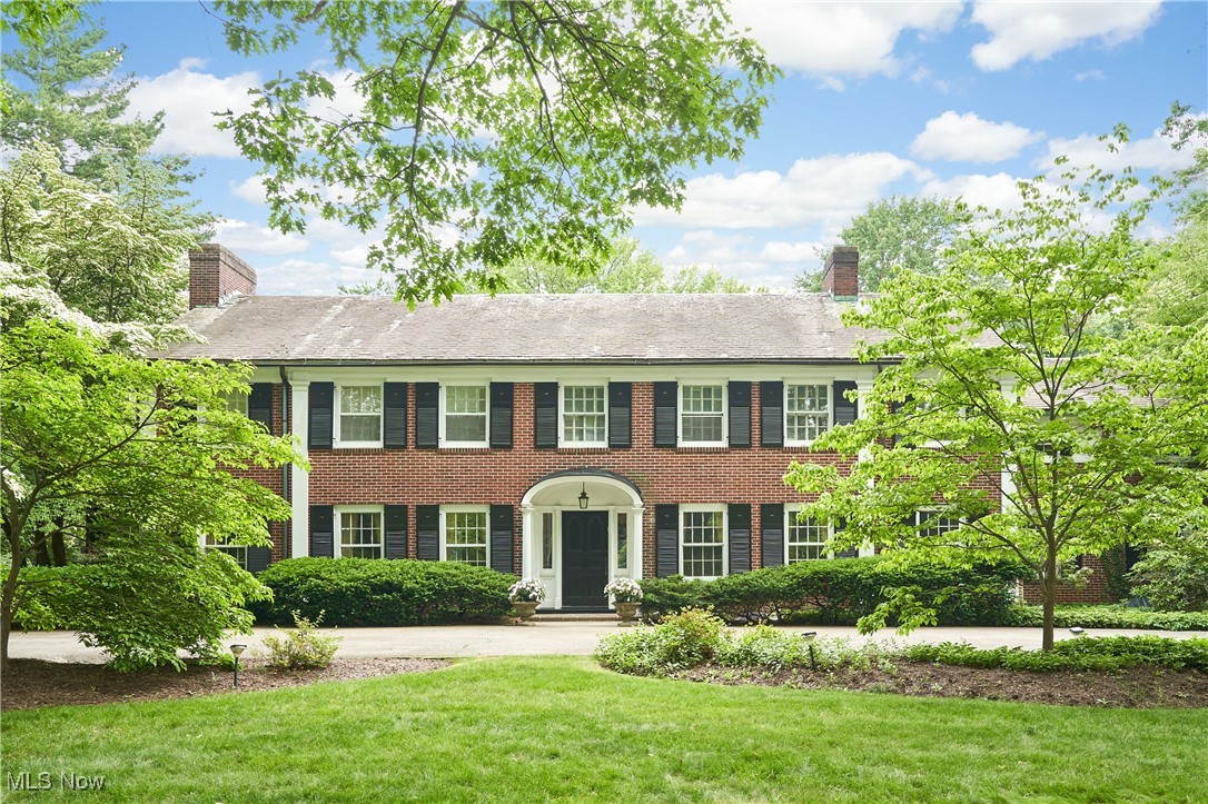 Nestled on a lush, private lot, this stately 1928 Georgian Colonial is one of two “sister homes” designed by renowned architect Roy Firestone, perched atop Ridgewood Road in Fairlawn Heights. With 6 bedrooms and 5.5 baths, the residence blends timeless elegance with thoughtful updates for modern living. The grand marble foyer sets the tone, leading to sweeping formal gardens and a fenced, in-ground pool and pool house w/half bath and outdoor kitchen. The main level includes a marble-floored dining room with hand-painted chinoiserie wallpaper, a refined living room with marble fireplace and parquet floors, and a sunlit garden room with antique chandelier, latticework walls, and curved privacy glass. The kitchen—renovated in 2023—features quartz countertops, WoodMode cabinetry, a large island with vegetable sink, hand-painted tile, high-end appliances including Electrolux, KitchenAid, and Fazar induction cooktop, plus Andersen 400-series windows. Adjacent is a stylish bar with marble top, a cozy library with fireplace, powder room with brass accents, and an expansive family room with new neutral carpet and fireplace. Upstairs, the primary suite offers a sitting room, walk-in closet, dressing room, and spa-like bath. Five additional bedrooms, including two in the original staff quarters, for a total of six bedrooms and four full baths. A hidden stair leads to attic storage. The finished lower level includes a rec room with fireplace, study, full bath, laundry, and heated two-car garage with extra storage. Guard VIP home warranty included for peace of mind! Lovingly maintained and rich in architectural pedigree, this is a rare opportunity to own a home of enduring character and refinement.