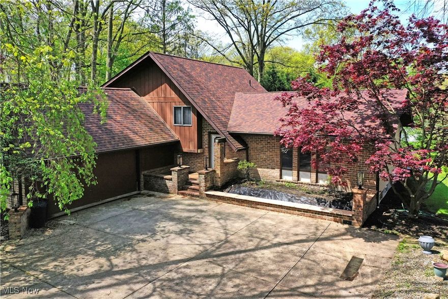 You will fall in love with the four levels and over 3600 Sq. Ft. of beautifully finished living space awaiting your arrival in this striking, Family Cherished Boardman home, available for the 1st time, with one owner.  Explore the expansive, move-in-ready living space as you immerse yourself in rich craftsmanship and gorgeous, beautiful design elements that populate the four-bedroom residence. Offering a unique experience from the inside out, the home sits on a tree lined lot within a park-like setting as the cement driveway is marked by lantern adorned, brick accent walls for a faux gated look. A towering Japanese maple blossoms with bold colors as it overlooks the main entryway. Meanwhile, tiered rear patio peers out across the lush backyard. Inside, the ornate foyer transcends into an illustrious living room with cream carpets and a mirrored accent wall that creates an extra sense of depth. Around the corner, formal dining awaits under its decorative lighting. The central kitchen completes the floor with its dark stained cabinets, tiled flooring and eat-in dining space, all the while a swinging door partitions off the main hall and stairway. Upstairs, a lavish full bath enjoys expert styling cues and matching lighting while the trio of bedrooms follow suit in their wallpaper and color choices. The larger master suite includes its own full private bath with opulent wall décor and a walk in closet.  Downstairs, a spacious lower family room includes a brick mantle with fireplace and a hidden wet bar for easy entertaining. An additional bath joins a brightly painted guest bedroom to include a breathtaking mural. Finished family space, fireplace and utilities are all located at the basement level.  The lower level has a direct walk out to the attached 2 car garage.  All this PLUS a 2-10 Home Warranty.