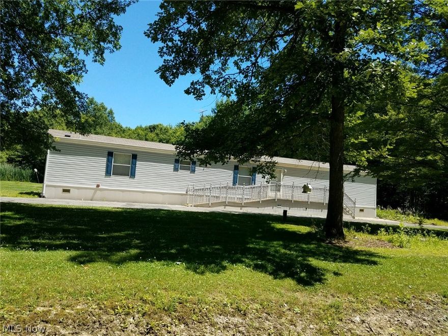 This well maintained property with 5 plus acres has open areas to the front and wooded to the back. This manufactured home has a ramp to the front door and also off the back deck.  Features 3 bedrooms, 2 full baths with eat-in-kitchen and laundry room.  Large deck 16x16 with access to the bonus barn.  The bonus barn is 13x26 has electric, is carpeted with paneled walls, cabinetry and closet as well as a porch.  There is a large garage 31x24 with separate electric box, dryer connection and concrete floor.  This garage has one overhead door with opener and a passage door. Additional storage barn with wood floor is 12x20.  All out buildings are wood exterior.