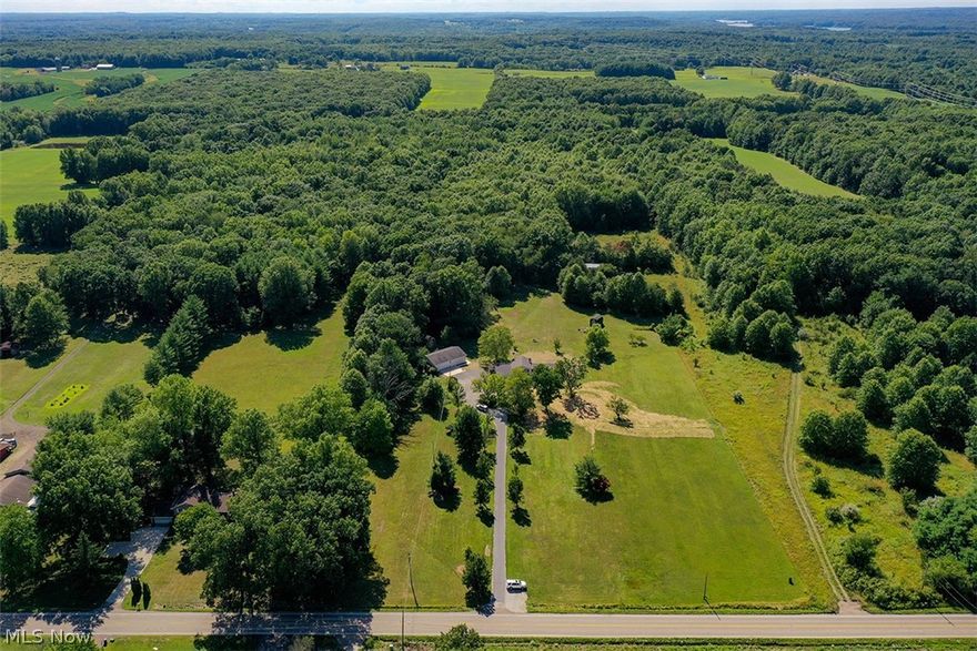 Three Bedroom Split Level Home with Many Key Updates and Outbuildings - 22+ Acres - FREE GAS - Portage Co. - Palmyra Twp - Southeast LSD. Great recreation property with lots of wildlife! The majority is wooded land with groomed trails, open in front with the house set back off the road. Home features a front living room with hardwood floors and a guest closet, a dining room with hardwood floors and sliding doors to a 14x24 covered deck, and a brand new 12x17 concrete patio. White kitchen with stainless steel gas range and refrigerator. Three bedrooms on the upper level with and full bath. Large lower level family room, laundry area with 2019 Samsung washer and dryer, and half bath. Forced air gas furnace, electric backup unit 2020, central air, hot water tank 2020. Well water with reverse osmosis system 2020 and new septic 2022. The home has updated windows and exterior doors throughout, new blinds in 2020, and carpet in 2019. Attached and finished two-car garage and large gravel parki