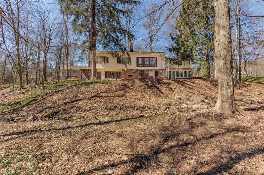 Home sits on the side of a hill with a creek running the length of the lot very nice views of the creek and woods. Heavily wooded lot but very little grass to cut, if your looking for a large yard this is not your homesite. Highly desirable Revere schools in a equally desirable neighborhood.