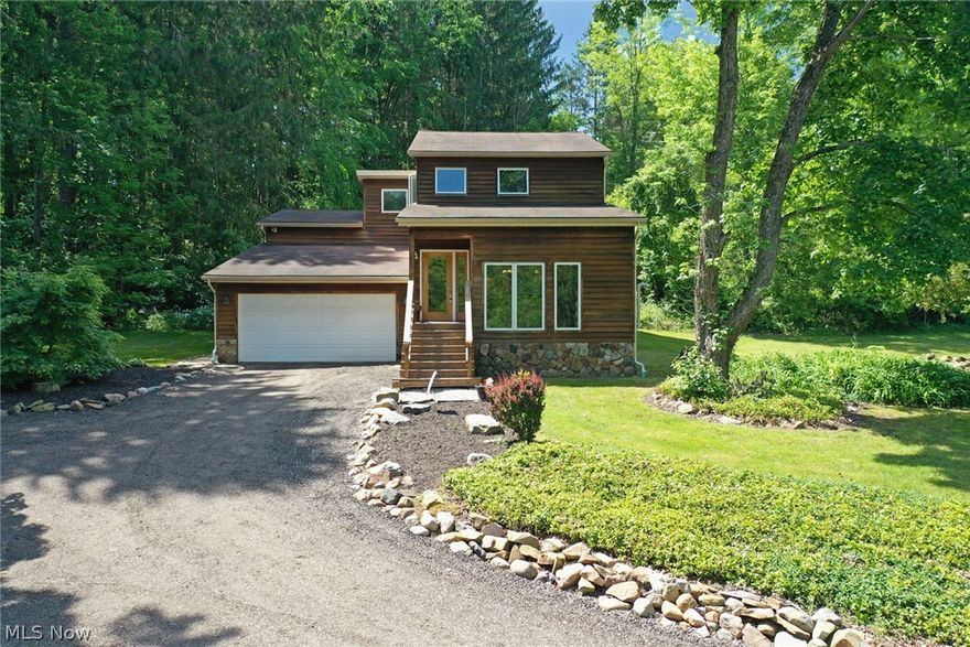 This Contemporary multi-level home is nested on nearly 2.5 park-like acres and borders the Chagrin River! Set back from the road, this home includes 4 Bedrooms & 3.5 Baths. The spacious open Foyer welcomes you into the main Living/Great Room with vaulted tongue & groove wood ceiling, stone fireplace with pellet stove insert & built-in corner wet bar. Eat-in Kitchen with granite counters, all appliances included & dining area with access to back patio. Dining Room has a 2nd pellet stove for supplemental heat. Spacious Master Bedroom includes a walk-in closet and Master Bath with soaking tub. 2nd Bedroom has its own private bath with shower. The 2 additional bedrooms both have hardwood floors and a full bath to share. New boiler installed 2016. Lower level includes half bath and access to large heated workshop and 2+car attached garage. 32x24 Outbuilding with newer metal roof, ideal for the hobbyist or additional storage. Set on 2 parcels with river frontage and close to Holden Arboretum