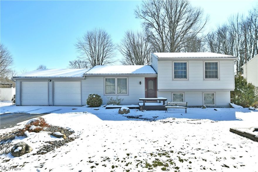 With springtime just around the corner, start your season right with this lovely Cortland split level, offering up four floors of beautiful, move-in-ready living space plus a basement! Located in a desirable neighborhood along a quiet side street, this home quickly attracts with its handsome grey and white colored exterior and stone landscaping. Don’t let the snow hide the advantageous steel roof or impressive rear patio space that overlooks both the backyard and the included storage shed. A carpeted foyer welcomes you inside as the immediate living room is awash in the midday sun thanks to the large picture windows. Hardwood style flooring runs underfoot, adding to the warmth. Around the corner, the illustrious dining room provides scenic backyard views along with nearby garage access. The adjacent kitchen is trimmed in an array of painted wood cabinetry that offers a touch of country style against the shimmering countertops. Up the new carpeted stairs, the landing includes a charming full bath with a tasteful vanity. Three bright and inviting bedrooms increase in size, completing the floor with the natural wood-trimmed master. The spacious master bedroom offers great closet space. The two additional bedrooms are nicely sized with personal closet space. At the lower level, a gracious family room brings plenty of natural light while a second full bath tucks away with its tiled flooring and glass door shower. The laundry room with washer and dryer staying completes the floor with its additional storage space. At the basement level, utilities, workshop space, and even more storage can be found. Updates include: metal roof 2009, furnace 2014, HTW 2016, new carpet in master bedroom, upstairs hallway/steps, and foyer/steps to lower level 2023, plus a one year home warranty!