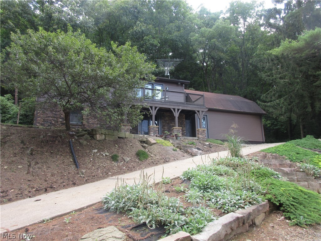 Enjoy picturesque lake views from this well appointed 3 bedrooms, 2 bath stone and vinyl home. Pine tongue and groove ceilings in the first floor living room. Hickory kitchen with breakfast bar and pantry. First floor bath with laundry room. Knotty pine tongue and groove ceilings in one first floor bedroom. 2nd floor offers an additional, private space with a stone gas fireplace in the living room and 3 french doors to the raised balcony. The second floor oak kitchen features a breakfast bar. Formal dining room includes french doors to the rear deck and 10 X 24 wrapped around front deck with scenic Tappan Lake views. Vinyl replacement windows throughout. 2 story 2 car detached garage includes a 2nd floor suite with tongue and groove ceilings. Private dock on the water. Lot#T-123. MWCD lease fee for 2018 is $1689.00. This unique home provides enough space for year round living or is the perfect retreat for the whole family. Includes range and refrigerator in both kitchens.