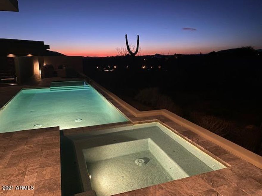 First time to the market, this fabulous contemporary home will take your breath away with an 16' ceiling and walls of glass. The owners have thought of everything including a separate wine bar room with passage to the patio, painted glass tile in the kitchen and quartz countertops along with an 18' stainless shelf, custom pantry with coffee bar/subzero refrigerator/freezer drawers/warming oven/ 2nd dishwasher and loads of storage, and a separate golf storage room with built-in bag and club and shoe storage. 2 guest suites are joined by a larger entertainment room with built-in storage and under-counter refrigerator. Master suite is spacious and has a coffee bar, under-counter fridge, his and her separate vanities and toilet rooms, large shower--2 separate closets and washer/dryer area. Covered patio area and artificial turf area,  poo/spa, pool bath, EVO grill and seating area with elevated gas firepit. Loads of guest parking and an oversized 3-car garage with abundant storage. Professional photos taken and will be added soon.