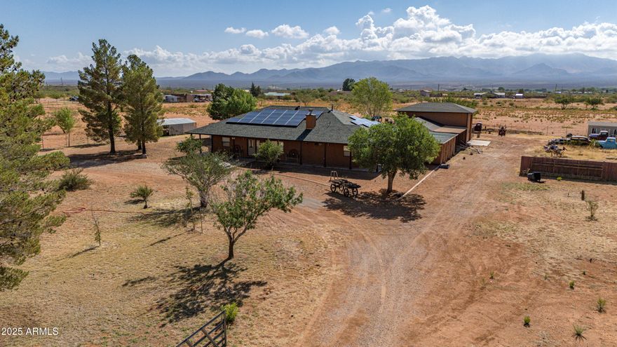 Discover the perfect blend of space, privacy, and convenience on this fully fenced 8.4-acre property with sweeping mountain views. Ideal for those who value peace, self-sufficiency, and room to grow, this property checks all the boxes.The 3-bedroom, 2.5 bathroom home features an additional den, ideal for a home office or guest space. The kitchen boasts granite countertops, ample cabinetry, perfect for entertaining or daily living. Car enthusiasts, hobbyists, and RV owners will love the incredible garage space: a 5.5-car garage, a dedicated RV garage with full hookups, plus a separate workshop for tools, projects, or storage. Solar power and enjoy the freedom of your own private well. A newer roof. Step outside to enjoy your own private oasis, featuring fruit trees, a greenhouse.