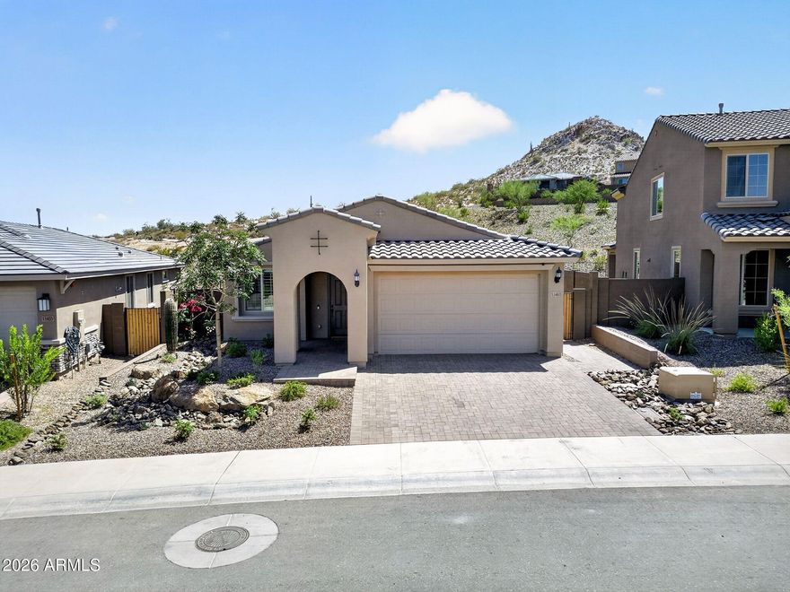Better than new! This 2024 Pulte Hewitt II sits on a premium hillside lot in Foothills at Northpointe with stunning mountain views and no rear neighbors. Over $140K in upgrades include a chef's kitchen with gas cooktop, canopy hood, built-in oven, quartz counters, tile backsplash, and walk-in pantry. Inside you'll find luxury vinyl plank floors, shutters throughout, recessed lighting, a den, beautiful primary bath with frameless glass shower. The backyard is built to entertain -- travertine hardscape, covered patio, built-in BBQ with island bar, firepit, and real grass. Smart garage door, Ring doorbell, tankless water heater, custom landscaping with paver driveway and walkway complete this truly beautiful and turn-key home.