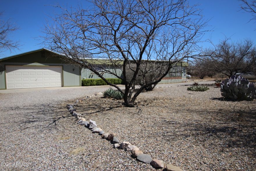 This 2 bedroom 2 bath home features 3 porch areas to take advantage of the wonderful Arizona weather.  Wood burning stove for those chilly evenings. Over 1400 sqft gives you lots of room inside.  All on 1 acre!  Located on paved roads, has a 2 car attached garage with extra large workman. Complete RV hook up for your winter visitors.  The garage received a new roof and house was cool coated in 2018.  All new plumbing in 2013, Carpet replaced in 2018.  This home is ready for new owners! Give me a call to schedule your private showing today.