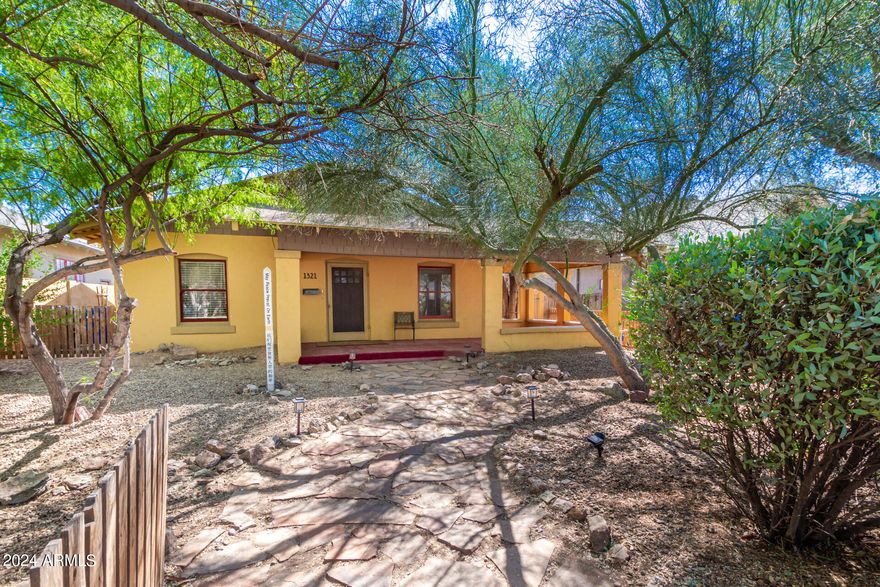 Looking for a new home within The Woodland  Historic District? This gorgeous 2 bed, 1 bath residence in the heart of Phoenix is the one! Featuring charming curb appeal, a manicured front yard w/mature shade trees, a flagstone walkway, and a welcoming front porch. Discover a sizeable living area w/elegant original hardwood flooring and a cozy fireplace. You'll also find a formal dining room ideal for hosting a dinner party! The galley kitchen is comprised of painted cabinetry w/quartz counters, subway tile backsplash, and stainless steel appliances. Each bedroom boasts its own private sitting room w/stylish French doors! Bathroom Remodeled as part of an Extensive Plumbing Upgrade in 2018.Finally, the backyard includes a covered patio, newly built workshop ,back alley access w/an RV gate