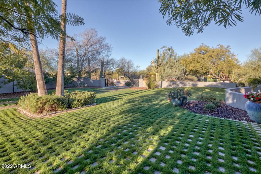 Just Reduced $100,000! This very private & quiet gated 4 bedroom home has a lush grass yard with Mountain Views, mature vegetation and a delightful outside ramada. It features beautiful paneled cherrywood ceilings, wide archways, vaulted ceilings, wood floors & 2 stone fireplaces  creating a warm & inviting setting. Fully open for entertaining, the main rooms have generously proportioned living spaces. It has a charming farmhouse kitchen with brick wall areas, high ceilings & clerestory windows, a breakfast rm, center island, stainless appliances & Subzero fridge. The spacious master bdrm hosts a fireplace & sitting area, & the Backyard has dual covered patios and overlooks the salt water pool, BBQ station & ramada. Perfectly positioned near the Biltmore between Lincoln/Camelback corridor.