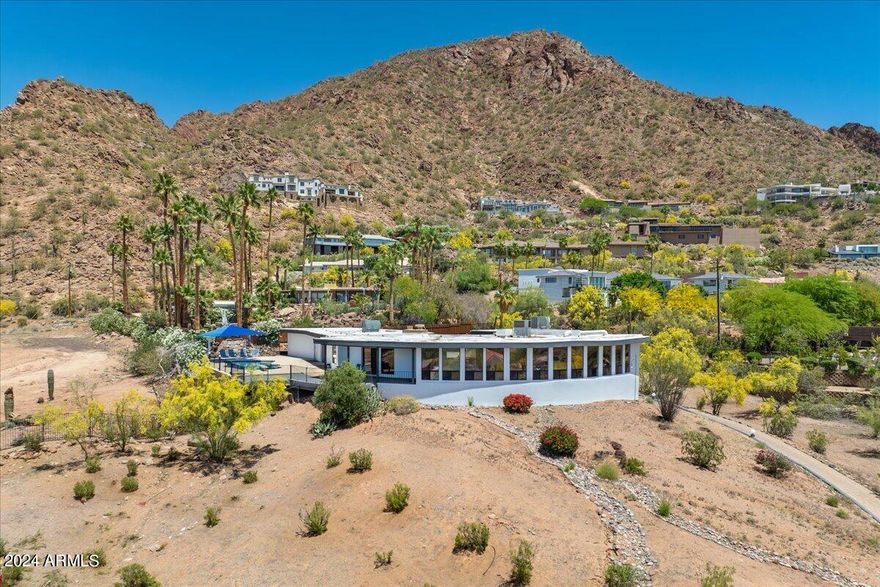 Welcome to your Camelback hillside oasis with breathtaking views of Camelback Mountain and the stunning cityscape! As you arrive, a tranquil private courtyard greets you. Step inside and be captivated by the magnificent city and mountain views that embrace every corner of this home, from the expansive great room to the dining area. Each room boasts its own window showcasing either the dazzling city lights or the majestic Camelback Mountain. The kitchen space is a chef's dream, offering ample space and top-of-the-line appliances such as a sub-zero refrigerator, gas stove, and Bosch dishwasher. Adjacent to the kitchen, a spacious eat-in area awaits, leading to your own private patio where you can enjoy al fresco dining surrounded by natural beauty. Step out onto your private deck and take in the sight of a sparkling pebble tec diving pool nestled at the base of Camelback Mountain, creating a serene retreat just steps away from your door. This thoughtfully designed floor plan offers a split primary suite, ensuring privacy and comfort. The primary suite is a haven of relaxation, featuring his and her closets and a separate exit that leads to your personal poolside sanctuary. Adjacent to the primary suite, a private den with a cozy fireplace awaits, providing the perfect space for work or relaxation. Bedrooms 2 and 3 are equally impressive, boasting ensuite bathrooms and walk-in closets for added convenience. Descend to the basement level and discover a versatile flex room, an additional bedroom, and a bathroom, offering endless possibilities for customization to suit your needs. This Camelback hillside home is not just a residence, but a sanctuary where you can immerse yourself in the beauty of nature and the allure of city living. Don't miss the opportunity to make this extraordinary residence your own.