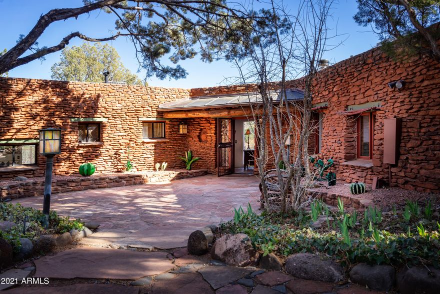 Come see why this elegant 6.5-acre equestrian estate won the hearts of Henry Ford's heirs! The gracious Old Sedona-style home & guest house with multiple patios, 31-ft. Italian tile pool & hot tub offer stunning Red Rock views. The park-like lot features shade trees, meandering river rock paths & over 850 ft. of riparian Oak Creek frontage.Petrified wood, agate & crystals are inlaid in house & patio walls. Viga beamed ceilings, adobe block interior walls, pine/saguaro cabinetry & Anderson windows complement stone exteriors. Spacious guest house boasts upstairs area perfect for studio/office or extra bedroom.The charming 4-stall stable features hanging lanterns & English-tradition stall fronts by Loddon Equestrian of Norwich, UK, & is crafted from Eki African hardwood, stone, copper & vigas