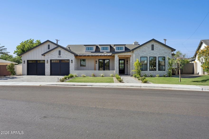 With its beautiful blend of painted brick, clean architectural lines, and modern farmhouse charm, this exceptional new construction home makes an immediate impression in the heart of Arcadia Osborn. Inside, the home unfolds with a thoughtful, highly livable floorplan designed for both everyday comfort and elevated entertaining. The kitchen anchors the main living space with an oversized island, Taj Mahal quartzite countertops, and custom cabinetry, creating a natural place to gather. A private office offers flexibility for work or study, while the dedicated dining room is ready for everything from intimate dinners to holiday celebrations. The primary suite feels like a true retreat, complete with a spa-inspired bath, a soaking tub, an oversized shower, and a generous walk-in closet. Each of the additional bedrooms is privately positioned away from the primary and features an ensuite bath, making the layout especially functional for family and guests. Outside, the backyard extends the living experience with a great patio and outdoor kitchen. Designed for both quiet evenings, easy entertaining, and the way families live today, this stunning new build comes together in one of Phoenix's most beloved neighborhoods. where new construction, charm, and location are rarely found in such balance.