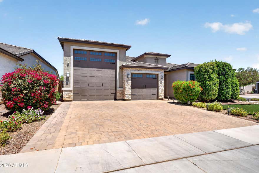 The Ultimate Setup for Off-Roaders, Boaters & RV Enthusiasts. This 3-bed, 2.5-bath home with a flex room and a massive RV garage is tailor-made for those who live for the outdoors. With Lake Pleasant just 30 minutes away and immediate access to off-road trails, this home offers not just luxury but freedom. Skip the monthly storage fees. Your oversized RV bay includes an epoxy-coated floor, RV clean-out, dual mini-split A/C units, and custom storage, ideal for your boat, UTV, or Class A rig. There's plenty of space for your gear, tools, and toys, all right at home. Inside, the upgrades continue with custom barn doors, a built-in shoe rack, motorized blinds, and designer hexagon LED lighting in the garage. The kitchen features a Cafe Series GE oven and range along with a Samsung Smart Hub fridge, all part of a black matte stainless steel, fingerprint-resistant suite. Premium window treatments, upgraded flooring, and a 7-camera NVR security system complete the polished interior.  A dedicated flex space offers the perfect setup for a home office, gym, or playroom ready to adapt to your lifestyle.  Step outside to your private backyard retreat featuring $30,000 in professional landscaping, a custom pergola, commercial-grade bistro lighting, and a 4-person spa, perfect for relaxing after a day on the water or trails.  Additional upgrades include a whole-home soft water system, additional garage laundry setup with washer hookup, and smart-home conveniences throughout.  Whether you're seeking adventure, space, or simply a better way to live, this home delivers it all without compromise.