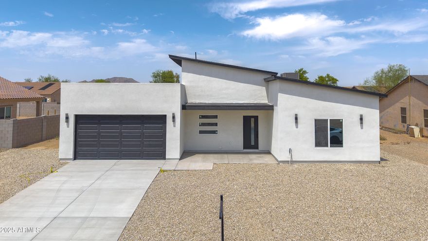 Rare single-level 4 bed, 3 bath home, hard to find at this price point. Bright, open-concept layout with a stunning kitchen featuring white cabinetry with glass uppers, a waterfall island with black-veined marble, and warm wood accents. Modern finishes and clean lines give the home a custom feel throughout.
Spacious living areas flow seamlessly, ideal for everyday living and entertaining. Seller willing to install block wall at buyer's request and offer concessions with a strong offer. Located in Arizona City with wide-open desert views, nearby parks, golf, and easy access to Casa Grande, Phoenix, and Tucson. Special incentives available! Qualified buyers may receive up to $10,000 toward closing costs or a rate buy-down, plus up to $10,000 in down payment assistance that never needs repayment.