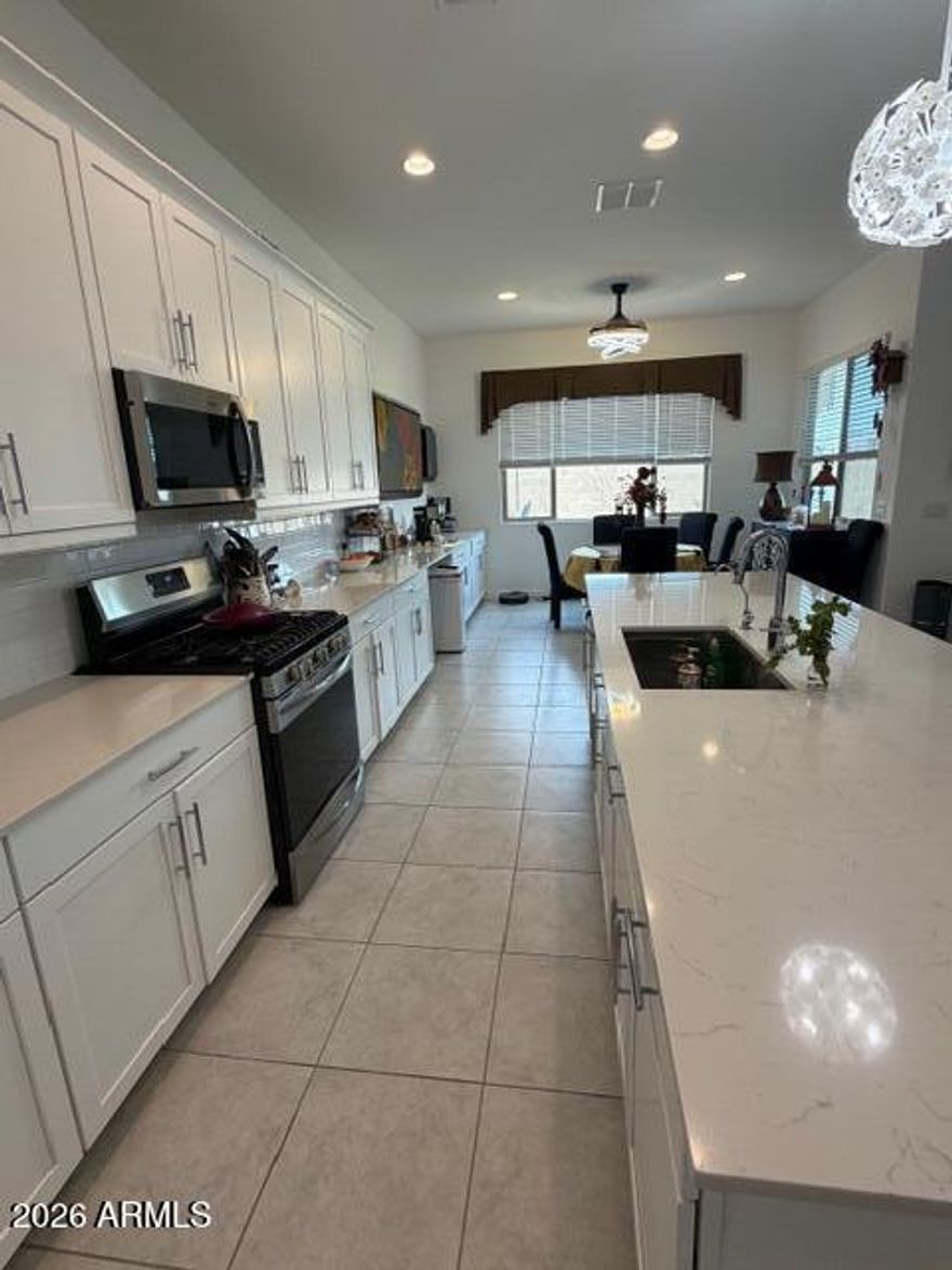 Beautiful highly upgraded Lennar NEXTGEN home with a full private entry 1 bedroom attached guest suite including a full kitchen and single car direct entry garage with its own private outdoor space. The main home has 3 very nice size bedrooms with 2 full baths and a beautiful, finished backyard with a custom stone waterfall synthetic grass, and built in bar area. Off to the side is a very serine garden area with citrus and herbs ready for your gourmet meal preparation. The main home has a secluded primary bedroom with an upgraded primary bath with separate dual vanities, fully tiled shower, and a huge walk-in closet.  There are two other nice-sized secondary bedrooms and a full bathroom on the front side of the home away from all the living areas. The Main kitchen has extended cabinetry. with matching counters that flow into the dining area and an OVERSIZED island. Both homes have plenty of additional recessed lighting with custom fans and light fixtures. Custom gated entry to both front doors at the front of the home. Professionally installed pet door enters into a small secluded and safe dog run in the back yard.  Come see today!