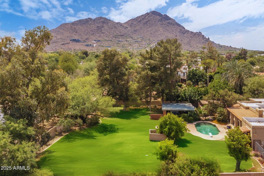 Nestled in one of Paradise Valley's most lush and serene pockets, this expansive property offers breathtaking views of Camelback Mountain and endless potential. Situated on a quiet cul-de-sac, the home welcomes you with a flexible floor plan anchored by an immense great room and a generous primary suite complete with dual vanities and dual walk-in closets.  The guest suites and bonus spaces offer incredible flexibility. Outdoors, you'll find a resort-style pool surrounded by mature landscaping, lush green grass, a charming gazebo, and a garden retreatâ€”creating a private, peaceful oasis perfect for entertaining or relaxing under the desert sky. In addition to the main garage, the extended 30-foot garage is ready to accommodate your boat, RV, or car lifts. Whether you choose to expand the existing home or reimagine the space entirely, this property is a rare opportunity to craft your dream home in one of Arizona's most coveted neighborhoods.