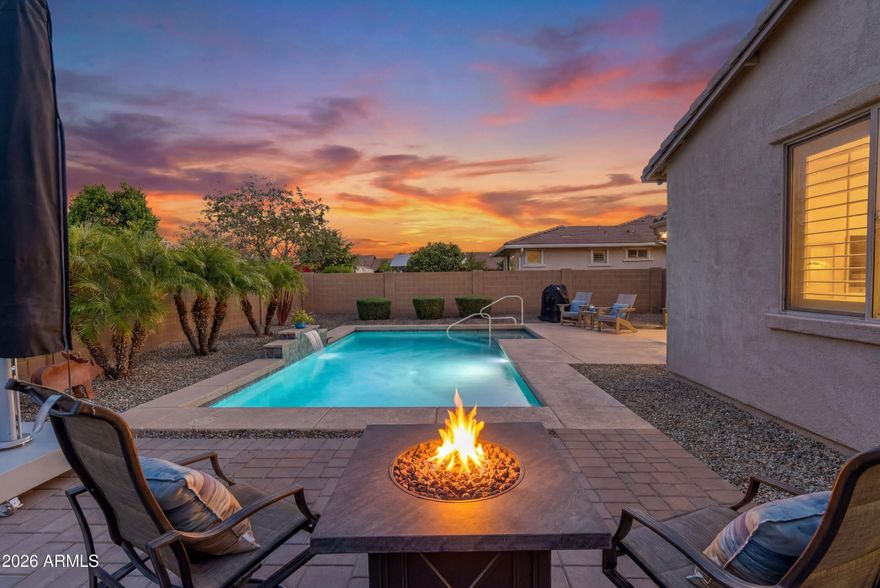Gorgeous Pool home in Encore at Eastmark! This spacious home has a terrific open floor plan with effortless flow between the kitchen, dining, and living areas, ideal for both quiet mornings and lively gatherings but the showstopper is a sparkling backyard pool with a waterfall feature. The kitchen anchors the home with rich dark wood cabinetry, beautiful granite countertops, and a generous center island that's as practical as it is striking -- perfect for cooking, casual meals, or entertaining guests. Wood-look tile plank flooring lends warmth and easy care, holding up beautifully to Arizona living.
