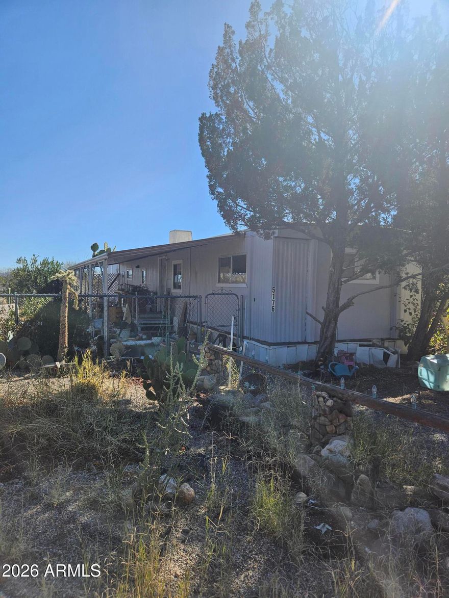Investor special! Fixer Upper. 2 bedroom, 2 bath. Split bedroom plan. Open living area. Metal carport type awning runs for most of the length of the front of home. Patio with lattice in the back of home. Good sized chain link fenced yard. Storage shed in backyard. Home is on a perimeter lot with mountain views. Additional alley access. Home sold ''As Is'' with no personal property or debris to be removed.
