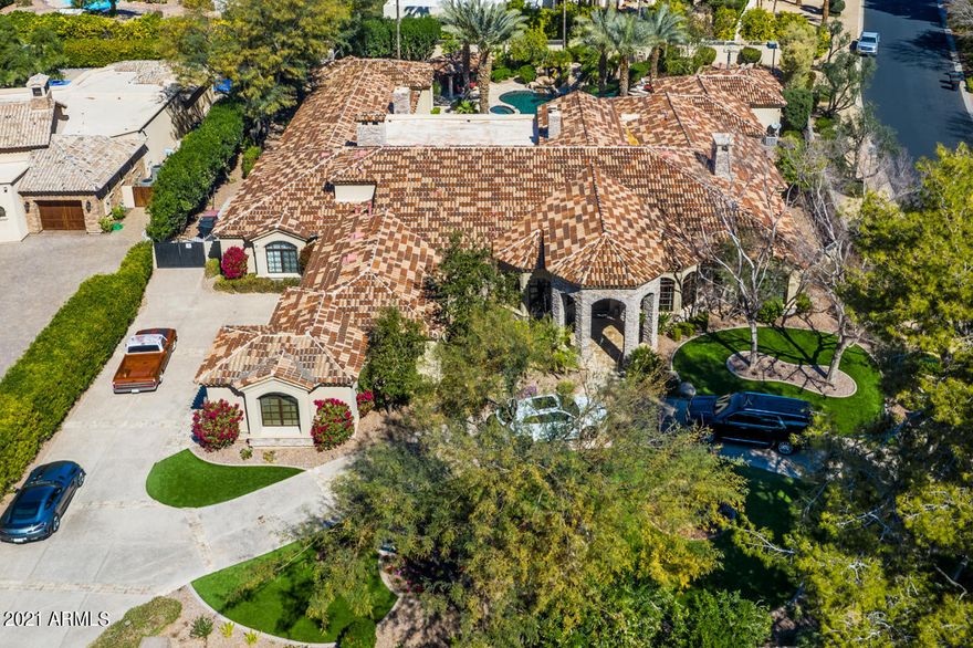 Imagine coming home to this gorgeous house in the guard gated community of Equestrian Manor Estates in Scottsdale. This stunning 6-bedroom, 8-bathroom  4-car garage home giving you over 7,400 sq. ft. of spacious elegance, offers amazing features such as a walk-in wine cellar with a massive home bar perfect for displaying your favorite spirits, while entertaining in style. 
 
From the open-concept living space with exposed decorative ceiling beams with plenty of room for the whole family to enjoy while sitting in front of the fireplace or sitting at the counter in the gourmet chef's kitchen with a Sub Zero refrigerator/freezer, Viking gas range and ovens, large walk-in pantry, 2 dishwashers, warming drawer and a center trough sink with usable prep space. This is also a great setup for family & friends to cook together without competing for space. There is also a wide range of cabinets and drawers that are placed systematically all over the kitchen for dinnerware, utensils, gadgets and kitchen accessories. 
There  is substantial room in all bedrooms, each room has a bathroom & walk-in closet. The owner's suite has a fireplace, large sitting area perfect for lounging, huge walk-in shower, separate bathtub, separate his and hers luxurious walk-in closets and toilets, exercise room with a spacious walk-in steam room and double doors that lead to the outdoor oasis.
 
Multiple guest quarters, with one that is currently being used as sports room with golf simulator the other serves as a guest house with full bath, walk-in closet, microwave and views to back yard that include a sports court, covered patio, full outdoor kitchen, relaxing ramada, water-slide into refreshing pool, jacuzzi, 2 golf putting greens, artificial turf in front and backyard, other features include 2 areas to cuddle up to a cozy fireplace with a good book or your favorite drink. Surrounded by beautiful trees and plants. 
 
The sizable office with built-in cabinets and bookshelves provides dedicated space if you need to work from home while providing the needed privacy. The home also offers security cameras throughout the home, smart home automation by Crestron that controls the climate, television, music and security system.  All of this is situated on a corner lot in a convenient, friendly neighborhood near hiking, dining and shopping. It's hard to list all the indoor and outdoor features of this stunning home. Schedule a tour today!