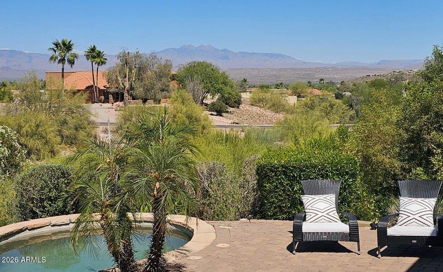 Embrace the beauty of desert surroundings in this exceptional 4-bedroom, 3.5-bath residence offering expansive living spaces, abundant natural light, and 4 Peaks views. High ceilings and an open-concept design create an airy sense of volume and comfort, while the great room is anchored by a striking Cantera stone fireplace, granite wet bar, and wine closet--perfect for relaxed luxury and entertaining. The well-appointed kitchen features stainless steel appliances, center island, pantry, and a generous dining space. A nearby flex area is ideal for media or formal dining, while the den w/closet offers flexibility as a guest suite or additional bedroom. Outdoors, a resort-style setting with heated pool, seamless desert beauty, and layered mountain views create a truly serene retreat.