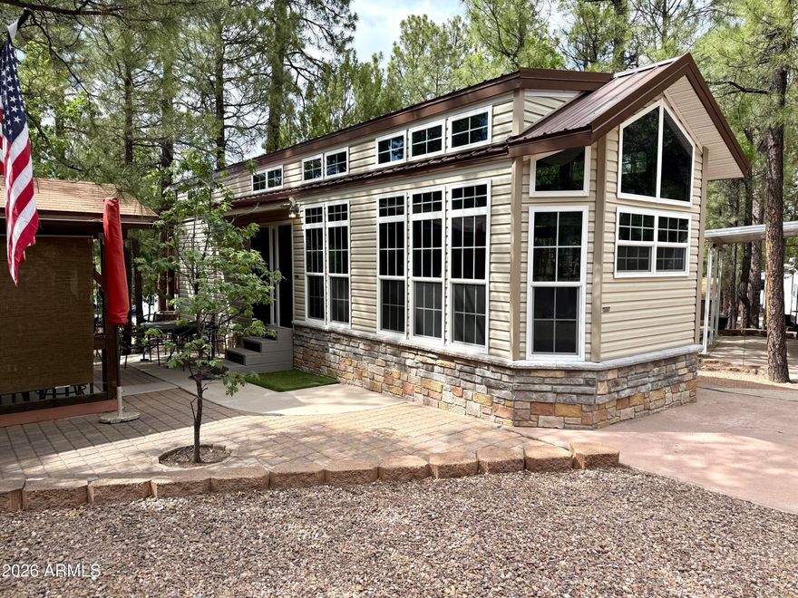 Rare opportunity in White Mountain Vacation Village! This fully furnished 2023 Fairmont Homes/Cavco Country Manor park model is move-in ready and loaded with extras. Inside features a huge loft, sunken primary bedroom, soft water system, WiFi heater in the primary bedroom, and TVs included. Enjoy the 10x10 covered patio with electrical outlets, ceiling fan, and Samsung TV, plus an oversized 8x8 shed with attic storage, washer, dryer, and fridge. Added upgrades include drip system irrigation with timer and landscape lighting. Community amenities include a large clubhouse with billiards, laundry, full kitchen, cornhole, horseshoes, and disc golf course nearby. Perfect mountain getaway or seasonal retreat!