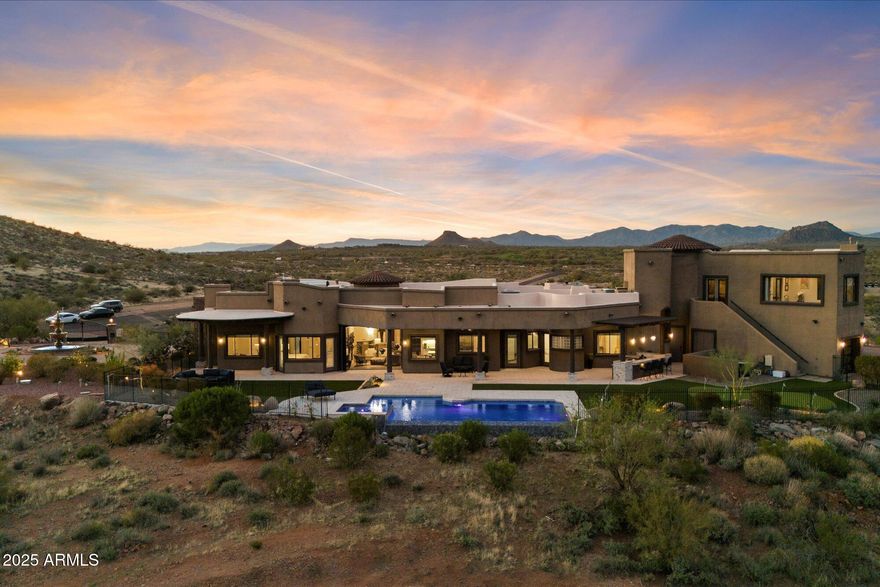 Outstanding value in N. Scottsdale! Upscale luxury meets desert serenity at this 5,110 sq. ft. custom Scottsdale estate on 2.98 elevated acres with sweeping mountain views. A show-stopping 5-car glass-door garage welcomes car lovers. Inside: five ensuite bedrooms offer sanctuary and seclusion, each with private patios and curated views, a chef's kitchen flowing to a spectacular signature living area with 16-ft sliding glass wall, opening to a south-facing yard with infinity pool, spa, misting system, putting green and outdoor kitchen. Enjoy a professional grade home theater and commercial-grade internet. Minutes to Scottsdale National and the Four Seasons. The best of Scottsdale living. Where luxury meets the desert sky. 27411 N. 120th St. 2023-2025 Home Upgrades and Enhancements
Exterior
120th Street was privately paved in 2024 by homeowner from Dynamite Blvd. to the driveway-note that Google Maps may not yet reflect this.
Backyard & Pool/Spa Renovation:
Automated pool equipment and plumbing;
Pool resurfaced with PebbleTec finish;
Full outdoor kitchen with built-in BBQ, smoker, and sink;
Wraparound misting system on terrace;
Cool deck pavers installed throughout backyard;
Artificial turf with custom putting green;
Outdoor lighting system around the entire property;
Renovated irrigation system;
Front flagpole added along with a second putting green; and,
Full exterior stucco painting.
Interior Upgrades
16-ft. folding glass door system with retractable screen in great room;
Professional Home Theater System;
Projector and surround sound system integrated into walls and ceiling (media room);
Equipment housed discreetly in media room closet;
Epoxy-coated floors in garage sized to accommodate a sports car lift;
Three new full-view glass garage doors installed;
Designer chandeliers and sconces throughout;
Dining room detailed with grasscloth wallpaper; and,
Remodeled powder room with updated finishes.
Technology & Electronics
Exterior surveillance camera system;
Commercial-grade wired internet; and,
Whole-home Sonos sound system.