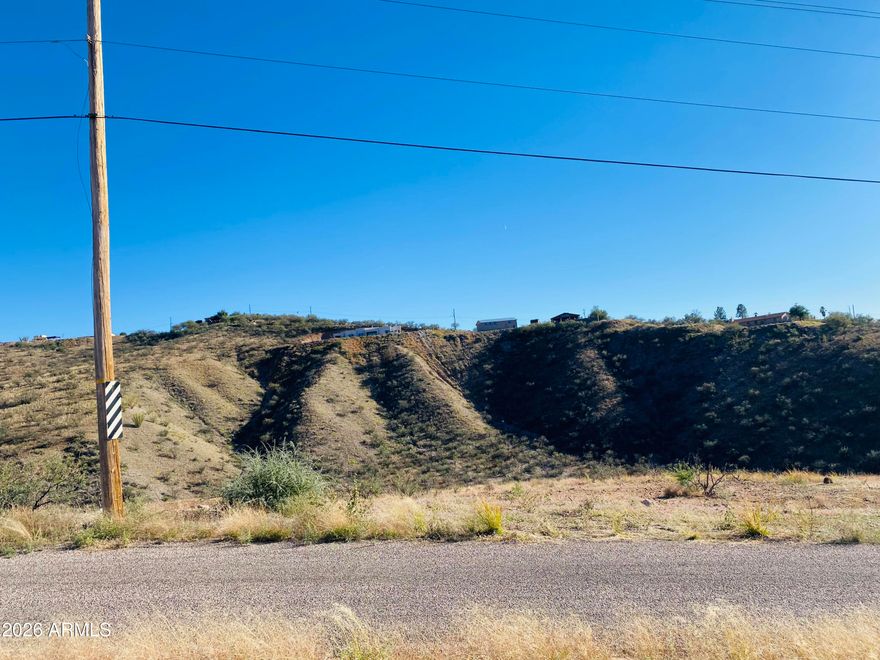 Nestled between two gentle ridgelines, this homesite offers sweeping valley views and a sense of natural privacy. Located just east of two neighboring parcels, the property sits moments from Interstate 19, Exit 17, providing quick access to shopping, schools, and everyday conveniences. Positioned off Rio Rico Drive, the lot features a soft, manageable slope--ideal for building your dream home in a peaceful, picturesque setting.