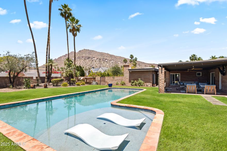 Sitting on nearly an acre in the heart of Scottsdale's coveted Arcadia enclave, this Two Hawks fully renovated 5-bedroom, 4.5-bathroom residence offers both charm and versatility—ideal as a family retreat or a unique short-term rental opportunity. The backyard showcases iconic Camelback Mountain views and is designed for entertaining with a sparkling heated pool, sport court, built-in BBQ, covered patio, and a large grassy play area.
Inside, an open-concept kitchen and living space highlight stainless steel appliances, walk-in pantry, a gas fireplace, wood-beamed ceilings, built-in shelving, and rich wood flooring. All en suite bedrooms, including the primary suite with a private exit to the backyard, walk-in closet, dual vanities, enclosed toilet, and an oversized shower. Additional upgrades include 2 car garage, new roof, and control four entertainment system and central server closet. 
Perfectly located just minutes from The Phoenician, Old Town Scottsdale, premier resorts, world-class golf, fine dining, shopping, and entertainment.