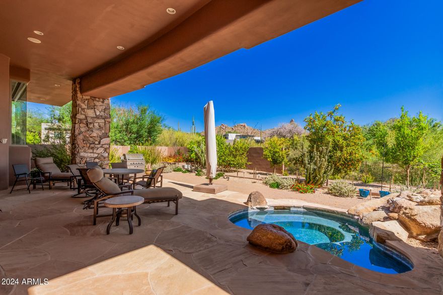 ESTANCIA GOLF MEMBERSHIP AVAILABLE SUBJECT TO BOARD APPROVAL. Single-level home on a 1.3 acre lot with south-facing views of Pinnacle Peak from the great room and master bedroom. This custom home has an open floor plan with large kitchen that flows seamlessly to the living and dining areas. Interior features include stone flooring, wood-beamed ceilings, custom cabinetry, stainless steel kitchen appliances, stone fireplace surrounds, 700-bottle wine room & adjacent wet bar. Exterior living area offers a large covered patio with TV area, gas fireplace, heated spa, built-in BBQ station, many mature citrus trees, and a rooftop deck plumbed for a bar with stunning panoramic views. Large solar panel system is owned. Oversized 3-car garage includes an electric vehicle charger. With all the features, views and Golf Membership... this home will sell fast!