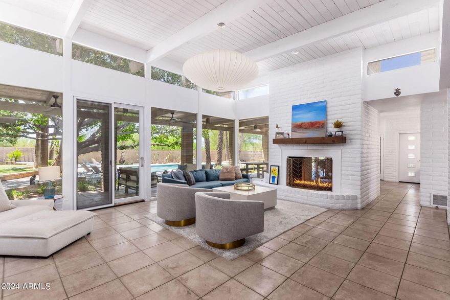 A VERY COOL, mid century modern property situated in an active and vibrant location nestled near the base of Camelback Mountain. Exudes a unique vibe, fun living space in a superior location. Surrounded by other remarkable homes, this fantastic pocket area of real estate in Arcadia has captured attention & admiration of everyone. The area is experiencing a surge in building activity, with several very large homes recently constructed. For the nature lover this gem is  a dream come true. Towering trees, even a rare tall Boojum tree, lush foliage &  majestic mountains create a breathtaking backdrop. Designed in a mid-century modern-organic style, lending a light, airy, and bright ambiance. Natural light floods in at every angle, illuminating the living spaces, creating an inviting atmospher Step into the recently remodeled kitchen which exudes Mid Century Modern, sophisticated vibe. The kitchen is a culinary enthusiast's delight, offering new appliances, sleek quartz countertops, shelving and ample storage space. Enjoy the double sided fireplace while cooking or dining. The master retreat  is a sanctuary of relaxation, with a cozy fireplace, separate sitting room, luxurious soaking tub, his & hers closets and exit to a private patio area. 
One of the bedrooms deserves it's own spotlight, it is either a teenager's apartment, an attached guest casita or a mother in law suite. However you use it, it has a separate entrance, living room, bathroom and bedroom! Convenience at your fingertips as you're within walking distance to The Camelback Village Gym, or indulge in exquisite dining experiences at renowned establishments like Steak 44, The Henry, or Aj's Fine Foods for your dinner parties. These culinary delights are within easy reach, allowing you to savor the vibrant local food scene here. Highly anticipated and welcome is The Global Ambassador, another hot topic in this area, offering even more unique dining! This home sits on just under an acre, larger than many others in this area, providing ample space for outdoor activities and entertaining. Take a refreshing dip in the sparkling large pool, bask in the Arizona sun , or retreat to your hammock in your private oasis surrounded by greenery. Unparalleled lifestyle in an a HIGHLY sought after location. The perfect harmony of natural beauty, mid century modern design, and convenient amenities create such a desirable living experience. Embrace the allure of this remarkable property and discover a haven for the nature lover in you.