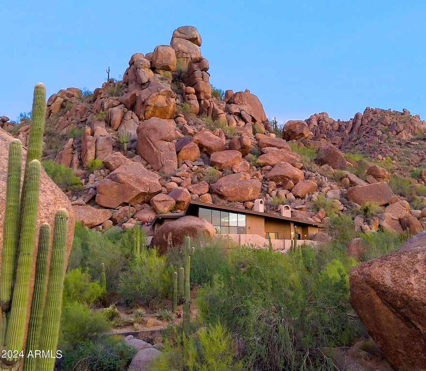 On the southeast side of Carefree's Black Mountain. This hillside landmark residence was designed by the legendary Carefree architect Gerry Jones. One of a kind desert contemporary home with stunning views of the Boulder pile, Pinnacle Peak, McDowell Mountains, and city lights. Only a block from the Boulders resort. Private gate. No HOAs. Nestled in the boulder outcroppings.  You will find the pool and outdoor spaces in the most private setting with amazing mountain and city lights views. The home has been designed with such harmony w/ nature and seamlessly blending the living space to the outdoors. Lots of recent upgrades & improvements. You will be impressed and captivated.  Rare opportunity to own an iconic residence. Perfect private vacation golf getaway or year-round residence