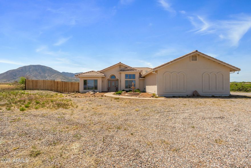 Custom Home Set on 7.40 acres with a PRIVATE WELL, paved road, stunning mountain views and ideal east/west exposure, this well-maintained home offers new exterior paint, newer appliances including the HVAC system, 3 bed, 2 bath plus a den or make it another bedroom home offers space, comfort, and privacy. Featuring 2,156 sq ft of living space, the split floor plan includes a spacious great room, cozy fireplace, and a dedicated study/den; perfect for working from home. The kitchen is equipped with a breakfast bar, island, pantry, and included appliances. The primary suite offers dual sinks and a functional layout. Landscaped front and rear yards feature a blend of natural desert, grass, and a low maintenance design on rolling hills! The backyard is set up for entertaining facing the Huachuca Mountains and a fenced area for your horses - approx an acre or expand it and make it your own!!  Plenty of room to add any out building too!