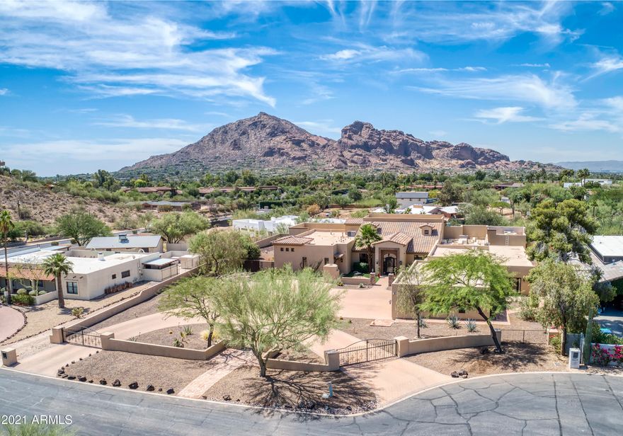 This Privately gated PV  property was completely rebuilt in 2012 using high quality finishes. Nestled between Mummy Mountain and the Phoenix Preserve allows for full unobstructed Camelback Mountain views. This 7,222 sq. ft. home with it's oversized 5 bedrooms, 5.5 baths. Grand entry, great room with custom stone work, fireplace and soaring vaulted ceilings is an entertainers dream. Master suite has a private office space, fireplace, his and her w/c, large jetted tub and oversized walk in close. Custom kitchen with 2 42'' refrigerators, 2 dishwashers, Viking gas range 3 ovens, wine frig. Open to family room breakfast  room and butler's pantry. Separate office, fully equipped bar and upper mezzanine and covered outdoor balcony. Separate Casita, pool, 4 car oversized garage and more