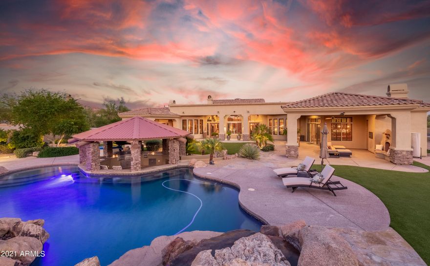 Welcome to the ultimate entertainer's paradise! Phenomenal home on nearly 2 acres of serene desert. Gated courtyard invites you to this awesome home! Numerous upgrades including open beam ceilings in living room, spacious double-island kitchen with high-end Wolf appliances, large family room with fireplace and adjacent wet bar and 800 bottle wine cellar, solid wood interior doors and unique accents throughout including stacked rock, brick and canterra stone. Double ice makers, double dishwasher, and double laundry setup! Split master features sitting room, plus his/hers closets. Check out the large media room too! Guest quarters with separate entrance complete this awesome residence! Backyard paradise with gazebo, swim-up bar, pool slide & plenty of covered patio! The list goes on and on!!