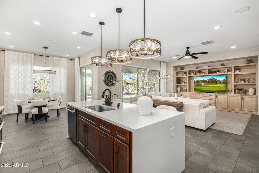 Former Model | $220K+ upgrades | Mountain Views | Mins from the 202!! Former model home with over $220K in designer upgrades, park-facing with mountain views! This stunning plan features wood-look tile, upgraded carpet, custom lighting/fans, surround sound, and a built-in entertainment center. Gourmet kitchen with gas range, quartz countertops, tile backsplash,42''maple cabinets, stainless appliances, and a waterfall island with seating. Spacious great room with MULTI-SLIDE doors for seamless indoor/outdoor living. Backyard designed for Arizona living with built-in BBQ, gas line, pergola, pavers, and putting green. Fresh interior paint, water softener, filtration system under kitchen sink, upgraded front yard with extended pavers, smart AC controls, and twilight lighting.Easy access to 202 Easy access to Loop 202 to go to Chandler Located Minutes away from the South Mountain loop 202 to easily travel to East or west valley. This home is filled with so many upgrades that the pictures don't show the True Beauty of the home.