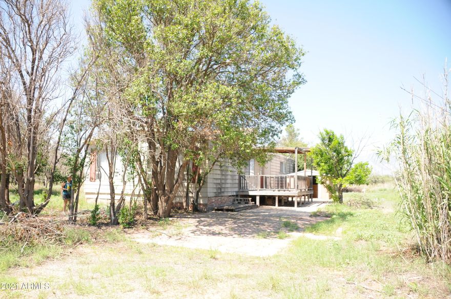 Property is priced for land only. Home has been vacant for years. It is attached to the property, but conveys with no warranty, guarantee or value. Property has horse facilities, and large grazing pasture that is fenced. Fence has old electric top wire. Pasture has it's on large gate (trailer size). Entire property is fenced. There are two storage sheds, a well house and access to a alley/utility easement. In the feed/tack room are three saddle racks. There are some items left on the property that buyer will have to deal with. Seller is unable to deal with removing them. Septic has just been pumped and inspected. Electric and water are on. Private well. There have been deer, javalina and quail while I was there.