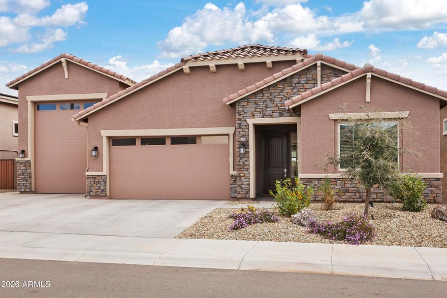 This is where refined elegance meets casual simplicity. This beautifully upgraded 3-bedroom, 3-bathroom home features an RV garage plus a 3-car garage--an exceptional setup for anyone who loves space, hobbies, or adventure.

Are you a car enthusiast? Add a lift in the RV bay. Prefer RV travel? There's plenty of room for your rig, vehicles, side-by-sides, golf carts, or even the ultimate man cave. This Wayfarer floor plan is designed for both private enjoyment and effortless hosting.

The front bedroom is a true en-suite, giving guests the comfort and privacy they'll appreciate. The great room brings everyone together for the ''goings-on,'' while still offering a bit of separation for the dining area. (A floor plan is included in the listing for easy reference.) The seller spared no expense in upgrading the beautiful flooring throughout--Continued: beautiful flooring, an 8 X 34 Beechwood Erie plank look, other seller upgrades include Linen 2 tone paint, Quartz for the Kitchen and White Knight granite everywhere else, custom draperies and woven shades, blackout drapes in the owner's suite, Kitchen Island custom woodwork, stunning pendant lights, chandelier, ceiling fans, surround sound too. The location allows additional privacy as it backs an approximately 30-foot community landscaped area which is perfect for their entertaining style which shows off the lovely backyard landscaping, travertine pavers (cooler than pavers), 2 patio sitting areas, artificial turf, custom lighting, mature trees, shrubs, plants and raised garden beds, a garden fountain, custom designed BBQ island with; extra burner, soft close stainless drawers and trash bin, bar sitting area and all beautifully tiled. The huge garage includes floor coating, extended cabinets at 13 x 10 feet, game room shelving and a tv mount. Other extras include Sunscreens for all windows, front yard adjustments with decorative boulders, contouring and custom lighting. This community is about 35% complete, and at the finalization there should be about 1,500 homes. Great news for this home purchase is all the work is done for you and this neighborhood is complete, a great bonus, no construction & landscaping installs to live with daily. Also, the location is 1/3rd of a mile to the stunning facilities where you can participate as much or as little as you like. The Clubhouse spans over 14,000 sq. ft. and features a state of the art fitness center, multi-use meeting space and stage area, resort-style pool and spa with water feature, spacious deck, fire-pits, covered patios and restrooms/shower facilities, the community is gated, has seven acres of lakes, twelve lighted pickleball courts, three lighted bocci courts, a 9-hole putting course with meandering stream, event lawn, multiple walkways and trails systems with ramadas and gathering spaces, dog parks for both big and small. The clubhouse hosts informational seminars, special interest groups, fitness classes, lifestyle events, plenty of card games and other fun events, we have included a monthly list herein as well. In addition, the city of Surprise is new and continues to add great entertainment and necessities, we are about a mile from a fire station, 5 miles from the Del E. Webb Medical center although a hospital is approved and planned much closer. So much fun to have at Village At Prasada - shopping and restaurants for everyone nearby. Surprise Stadum for spring training, Costco and Trader Joes, live theatre nearby too, this is a great city to call home!