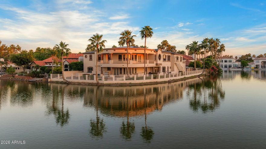 Experience a rare lakeside lifestyle in the desert within the gated community of West Lakes Estates. Tucked at the end of a quiet cul de sac, this timeless estate captures sweeping lake views and unforgettable Arizona sunsets, creating a truly picturesque setting. A grand staircase makes a striking first impression, setting the tone for the home's elegant interiors, including a formal dining room illuminated by a crystal chandelier. The spacious kitchen is designed for both beauty and function, featuring granite countertops, high end appliances, and an oversized island that flows seamlessly into the family room with a gas fireplace and soaring ceilings. A private home theater adds to the home's impressive amenities. The lower level is an entertainer's dream, complete with a secondary kitchen, expansive game room, 720 bottle wine room, private living quarters, and a fully equipped home gym.  Upstairs, five well appointed bedrooms plus an attached guest suite with its own kitchen and living area, ideal for extended stays or multi generational living. The primary suite is both grand and inviting, featuring a charming sitting room overlooking the lake, a spacious walk in closet, dual vanities, a jetted soaking tub, and a walk in shower. Residents enjoy access to community amenities including pickleball and tennis courts, all while being ideally located in one of Gilbert's most sought after neighborhoods. This is a rare opportunity to enjoy refined, resort style living with a lakeside backdrop in the heart of the desert.