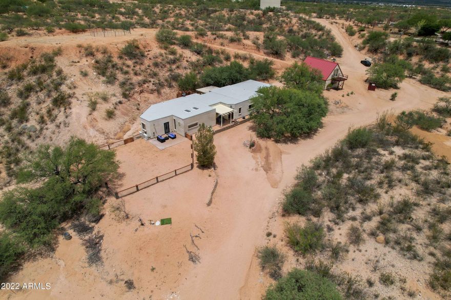 Gorgeous custom home on 10 acres with unobstructed views of the Dragoon Mountains. Five minutes from shopping and restaurants in downtown Benson but feels like a world away! Easy access to 1-10 and less than an hour highway commute to Tucson. Split bedroom floor plan that offers two bedrooms with en-suite bathrooms and plenty of closet space and third room with a 1/2BA that currently functions as an office but could be converted to a third bedroom or used as a den. The home also includes a dining area, spacious family room, laundry room, beautiful entryway, library and sitting room area, and kitchen with stainless steel appliances including a gas stove and brand-new refrigerator (July 2022) and dishwasher (July 2022). The family room includes a large picture frame window with clear views of the Dragoon Mountains and the beautiful sunsets. Wonderful decorative touches throughout the house including arches, decorator ceiling fans, stained concrete floors, sliding barn doors, and much more. Other recent upgrades include a new roof (2019), custom closet in the guest bedroom (July 2022), brand new wood look tile floor in dining room and library area (July 2022), and new granite top vanity in the main bedroom bathroom (2021).  The house also has a two-car carport, an elevated covered patio area in the front of the house for outdoor dining, a small patio to the side of the kitchen, and a large backyard patio for outdoor entertaining that includes a fenced area.

The home also boasts a separate barn/garage/workshop with metal roof and concrete floor that currently includes two large horse stalls (12' x 16') with rubber mats, a tack/hay room with 1/2BA that could serve as a third stall (extra rubber mats included), and a storage room behind the stalls for tools or tack. Above the stalls is another large bonus room with a closet and additional 1/2BA that could be used as a larger tack room, storage, or additional living space. Although currently functioning as a barn, the separate structure could easily be converted back to a two-car garage, workshop, or in-law suite. Additional horse facilities include a round pen, shavings pit, and large riding arena with solar lighting and a shade structure. The property also offers easy access to miles of beautiful riding trails. The home is on a private well and there is no HOA! A must see!!
