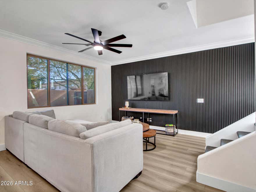 Tucked inside a gated community of just 12 homes, this detached 3-bedroom, 2.5-bath residence offers rare privacy with no shared walls in a prime central Phoenix location--minutes from Arcadia and the Biltmore. The home features luxury vinyl plank flooring (2023), custom wainscoting (2023), creating a clean, modern feel throughout. The kitchen is the only one in the community with a center island and includes granite countertops, espresso cabinetry, glass tile backsplash, pendant lighting, pantry, reverse osmosis system, and owned soft water system. Brand-new GE stove and GE dishwasher installed in 2025; all appliances included. Upstairs offers a spacious loft and convenient laundry room with added cabinetry.... The primary suite includes dual vanities, walk-in tiled shower, linen storage, and a walk-in closet. Secondary bedrooms are generously sized. Toilets replaced in 2023. Major systems include a 2016 HVAC (serviced 2026) and 2016 roof. The private backyard features a covered patio, artificial turf, and timed irrigation for low-maintenance living. HOA covers water, sewer, trash, gated access, community pool, and common area maintenance. Close to popular dining and easy freeway access. Move-in ready and one of the most upgraded homes in this boutique community.