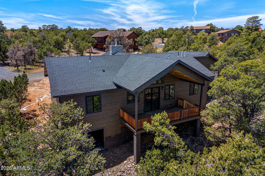 Brand New Build in Highly Desirable High Country Pines! Nestled on .40 acres, this stunning 3-bedroom, 2-bath home offers 1,494 sq ft of thoughtfully designed living space with an open, airy feel. Beautiful blue pine tongue-and-groove accents grace the ceilings and covered front and back decks, adding warmth and rustic charm. The inviting living area features a wood-burning stove/fireplace with dramatic floor-to-ceiling stonework, creating the perfect mountain retreat atmosphere.
Enjoy indoor-outdoor living with spacious decks ideal for relaxing or entertaining among the tall pines. Beneath the home, you'll find an impressive storage/workshop area complete with an 8' roll-up door, concrete flooring, and electricity -- perfect for hobbies, tools, toys, or additional storage needs. A rare opportunity to own a brand-new mountain home with quality finishes and functional extras!