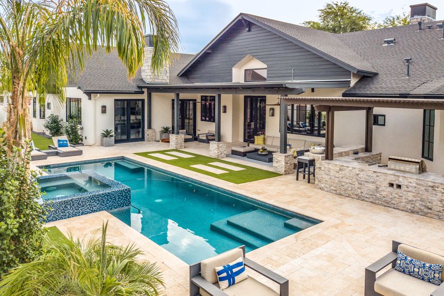 Amazing Arcadia opportunity, only 2 years old, this recently built custom home is absolutely gorgeous. With clean lines and outstanding design and architectural elements. The modern vibe is just what everyone is looking for in a home today. Sleek marble accents, oversized fireplaces, reclaimed wood beams, unique lighting, and exceptional millwork add to the glamour of this one of a kind home. The expansive feel is delivered by the pitch vaulted ceilings and the elegance of the hardwood floors that line your feet. The chef's kitchen has a comfortable refined feel with a top of the line Bertazzoni range, floor to ceiling cabinets, and a huge work island. Immediately upon moving in the owner added a ''wine collectors dream'' of a 1,700 bottle Custom Heritage Vine Wine Wall. Then he began a $200,000 renovation to the already existing new pool by adding a spa, pool heater, an outdoor kitchen area with a pizza oven, and additional entertainment space. The master is stylish and serene, with remote-controlled automatic blinds to darken the room at any time of the day. You will find every other room in the open floor plan is just as impressive. The colors are creative and the fully custom elements plentiful from the beautiful ceiling accents to the artistic tile. The home is finished with an over-sized 3 car garage, walking access to the cross-cut canal, and all of Arcadia's favorite dining and entertainment. Less than 10 minutes to downtown, Sky Harbor International Airport, and easy access to HWY 51 or 101 loop for access all over the valley.